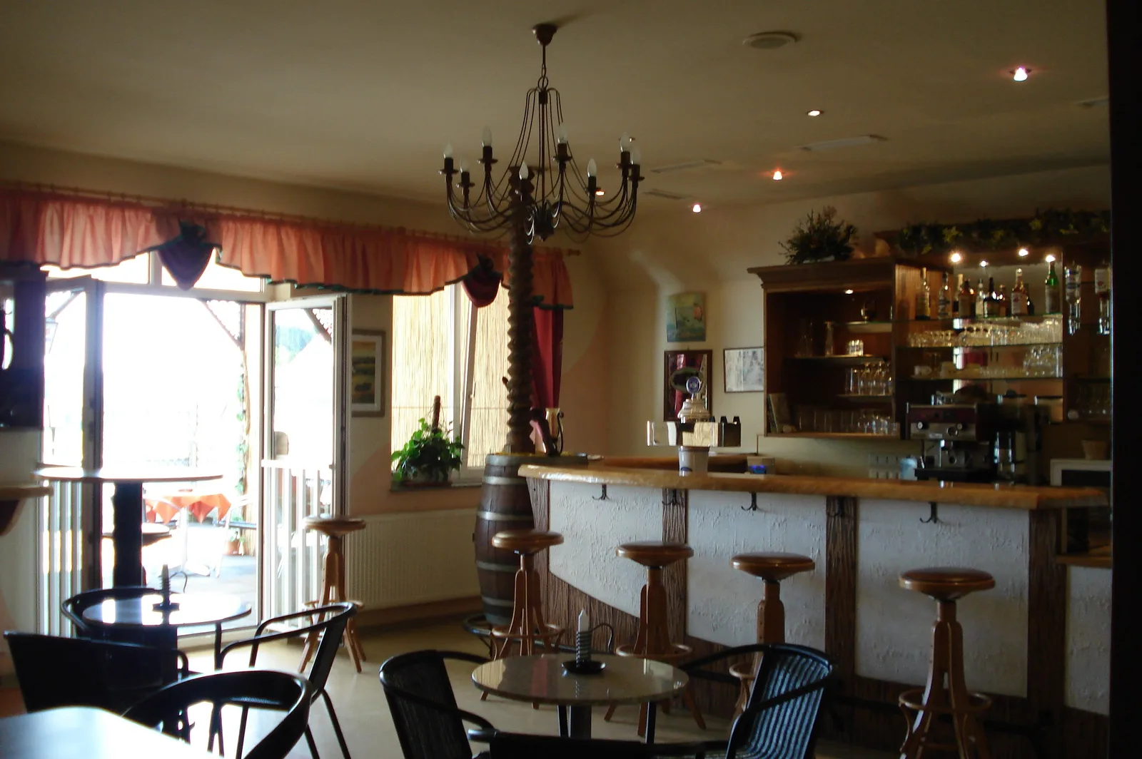 Innenraum des Cafes mit Theke, Barhockern und Luster
