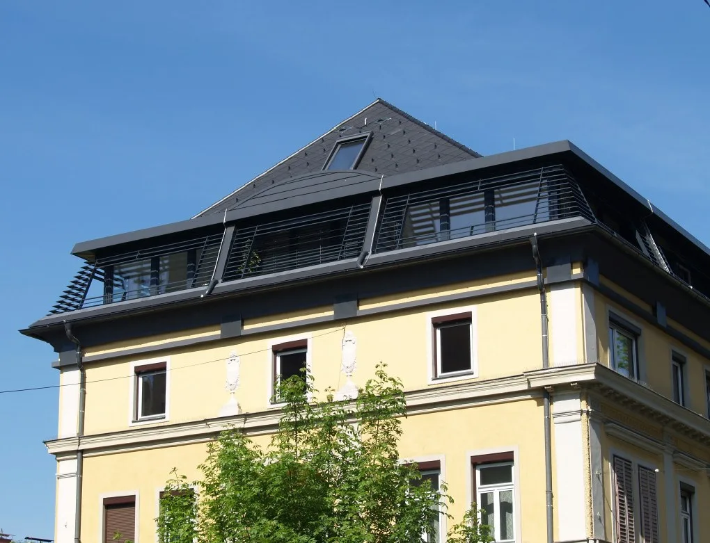 Fertig gedecktes Mansarddach mit Gauben und Dachflächenfenstern auf einem Altbau in der Schillerstraße in Graz
