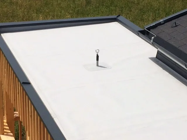 Fertige weiße Flachdachfläche mit Attika und Dachablauf